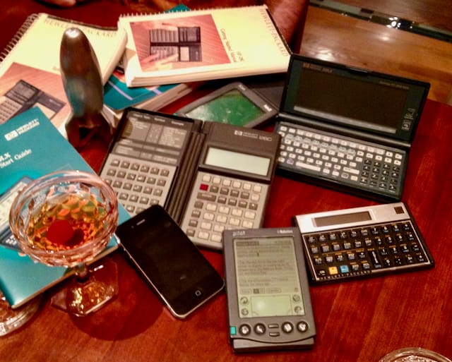 Old hand held devices and calculators and a cocktail in a coupe glass